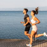 Aerial view of a pristine coastline with blue ocean water meeting a sandy beach, symbolizing the health benefits of blue spaces.
