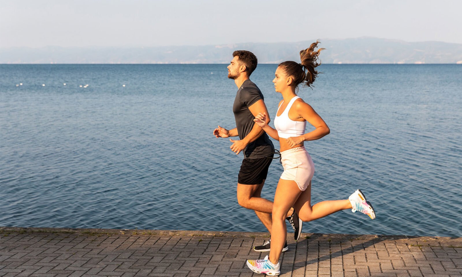 Aerial view of a pristine coastline with blue ocean water meeting a sandy beach, symbolizing the health benefits of blue spaces.