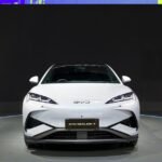 BYD electric vehicle driving alongside a Tesla, symbolizing the shift in EV market leadership.