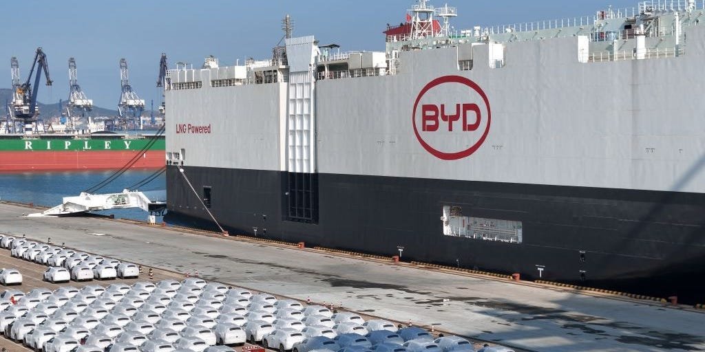 BYD electric vehicle next to a Tesla vehicle, representing the shift in global EV market leadership