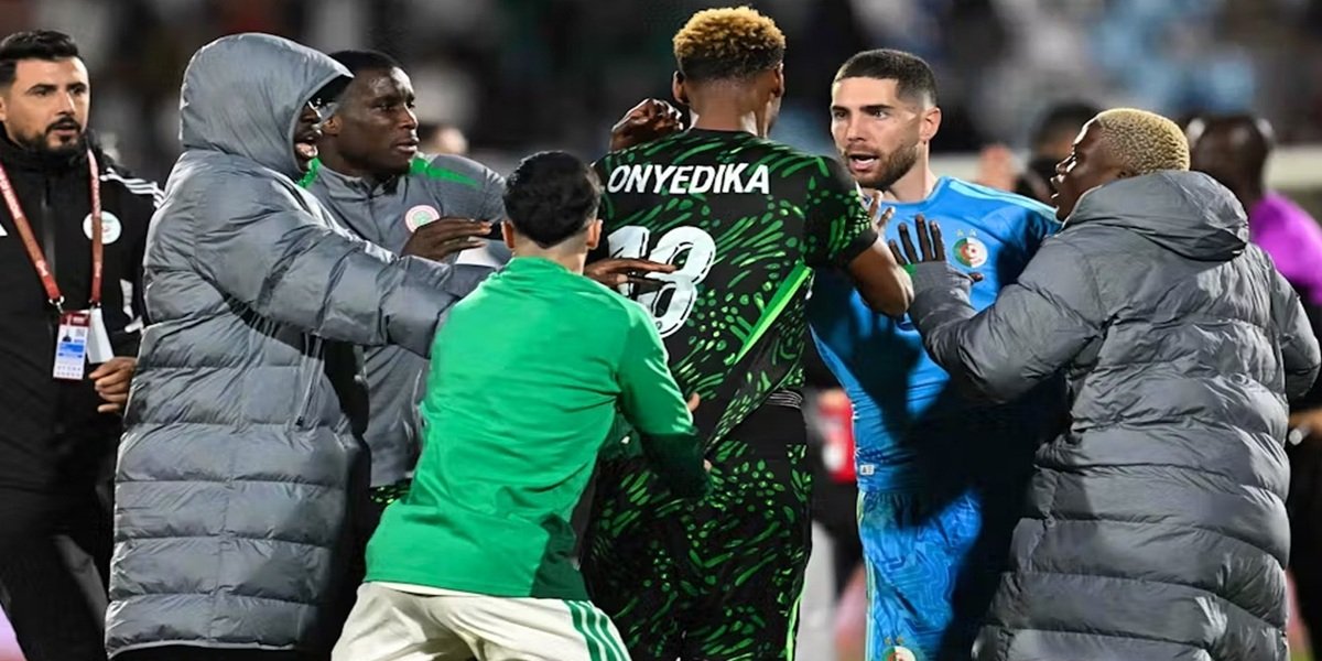 Scène de tension après un match de football, avec des joueurs entourant un arbitre et des forces de sécurité intervenant.