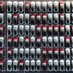 California Governor Gavin Newsom speaking, with electric vehicles in the background, symbolizing the state's commitment to ZEVs.