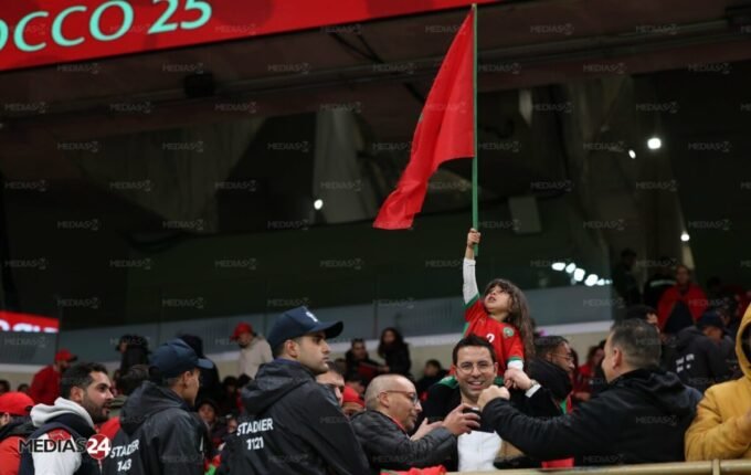 Vue panoramique d'un stade de football moderne au Maroc, illuminé lors d'un match de la CAN 2025, symbolisant le succès organisationnel du pays.