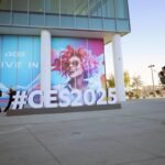 A man photographs a large CES 2025 sign in Las Vegas, symbolizing the anticipation and setup for the annual consumer electronics trade show.