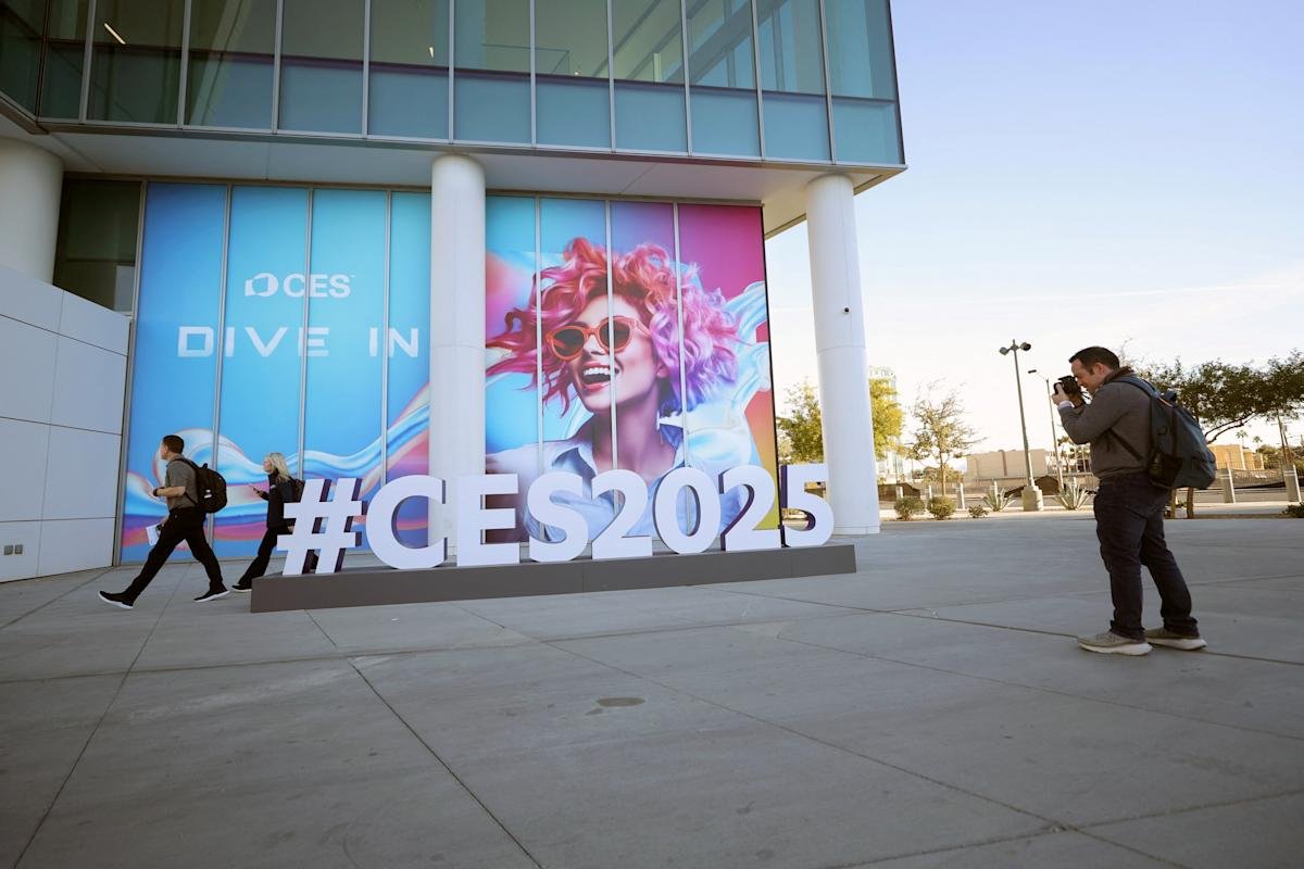 A man photographs a large CES 2025 sign in Las Vegas, symbolizing the anticipation and setup for the annual consumer electronics trade show.