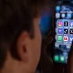 A child looking at a smartphone, with a parental control icon overlayed, symbolizing restrictions on social media access.