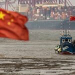 Shipping containers and gantry cranes at Yangshan Deepwater Port in Shanghai, symbolizing China's robust economic activity and global trade.