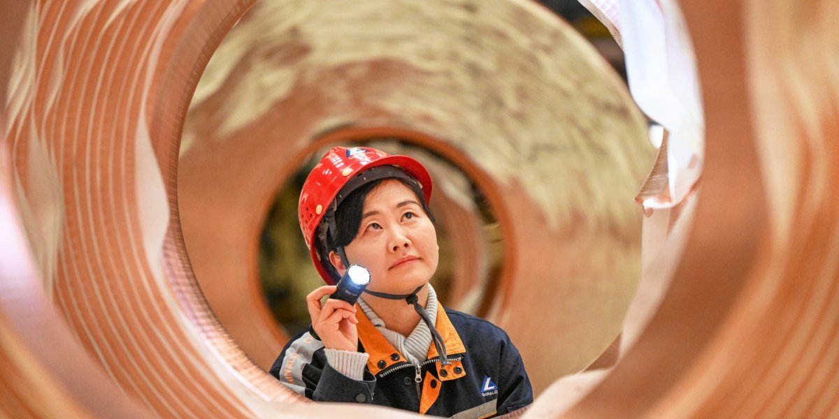 Shining copper ingots stacked in a warehouse, symbolizing global commodity markets and industrial demand.