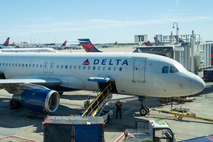 Delta Air Lines CEO Ed Bastian speaking, with a subtle nod to credit cards or financial graphs in the background.