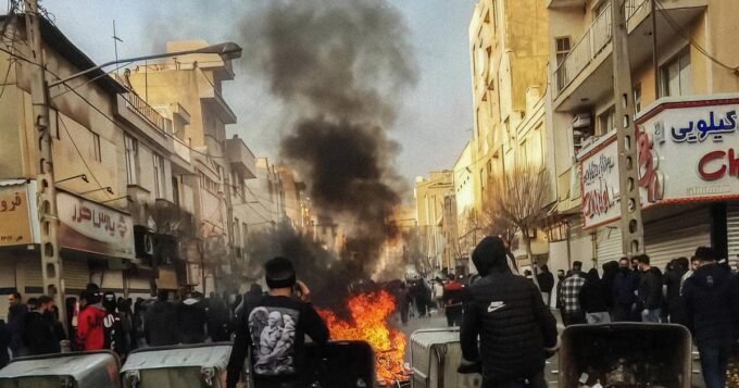 Manifestants défiant les forces de l'ordre dans les rues de Téhéran lors des protestations de janvier 2026, symbolisant la résistance iranienne.