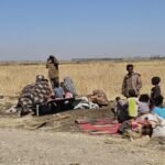 صورة تظهر أطفالاً سودانيين يتلقون مساعدات غذائية في مخيم للنازحين، تعكس الأزمة الإنسانية في البلاد.