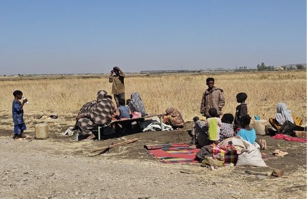 صورة تظهر أطفالاً سودانيين يتلقون مساعدات غذائية في مخيم للنازحين، تعكس الأزمة الإنسانية في البلاد.