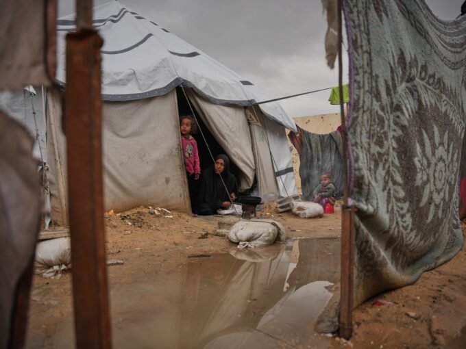 امرأة فلسطينية تطهو الطعام خارج خيمتها بعد أن غمرتها الأمطار في مخيم النصيرات بقطاع غزة.