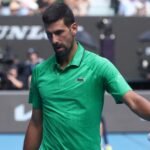 صورة لنوفاك ديوكوفيتش ولورينزو موسيتي يغادران الملعب بعد انسحاب الأخير من مباراة ربع نهائي أستراليا المفتوحة.