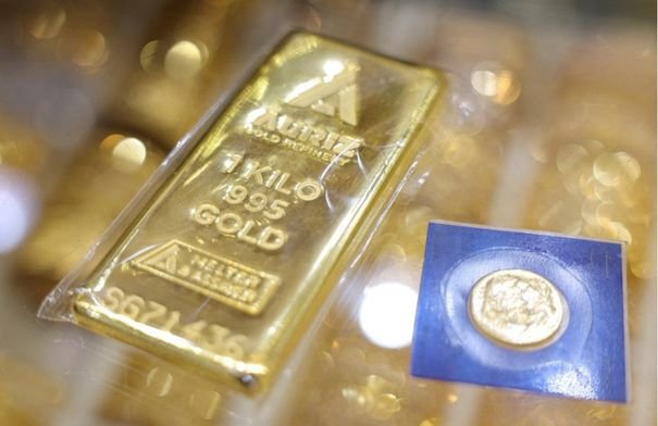 صورة مقربة لسبائك ذهب لامعة مع خلفية اقتصادية، تعكس ارتفاع أسعار المعدن الأصفر عالمياً.