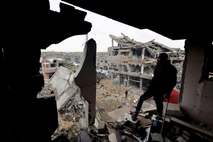 فلسطينيون يتفقدون موقع ضربة إسرائيلية في قطاع غزة