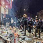 متظاهرون إيرانيون يحتشدون في شارع بوسط طهران يهتفون بشعارات مؤيدة للملكية، مع خلفية لمباني المدينة.