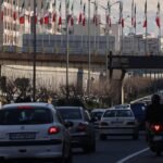 متظاهرون إيرانيون يرفعون لافتات في احتجاجات، مع خلفية تظهر قوات الأمن.