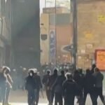 صورة تظهر قوات الأمن الإيرانية تستخدم الغاز المسيل للدموع لتفريق المتظاهرين في سوق طهران.