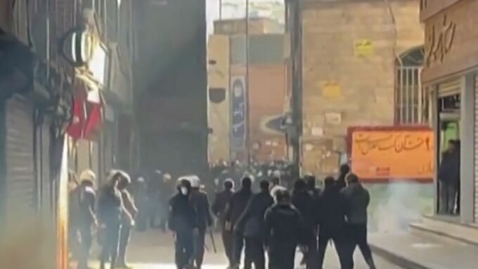 صورة تظهر قوات الأمن الإيرانية تستخدم الغاز المسيل للدموع لتفريق المتظاهرين في سوق طهران.