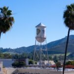 شعار وارنر براذرز ديسكفري مع خلفية تعبر عن صراع الاستحواذ بين الشركات الإعلامية الكبرى.