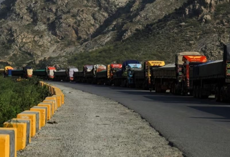 شاحنات بضائع متوقفة عند معبر طورخم الحدودي بين أفغانستان وباكستان، ترمز للتحديات التجارية.