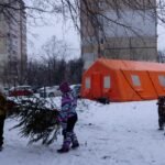 أطفال أوكرانيون يلعبون قرب خيمة لتوفير الطاقة والدفء في كييف بعد الهجمات الروسية.