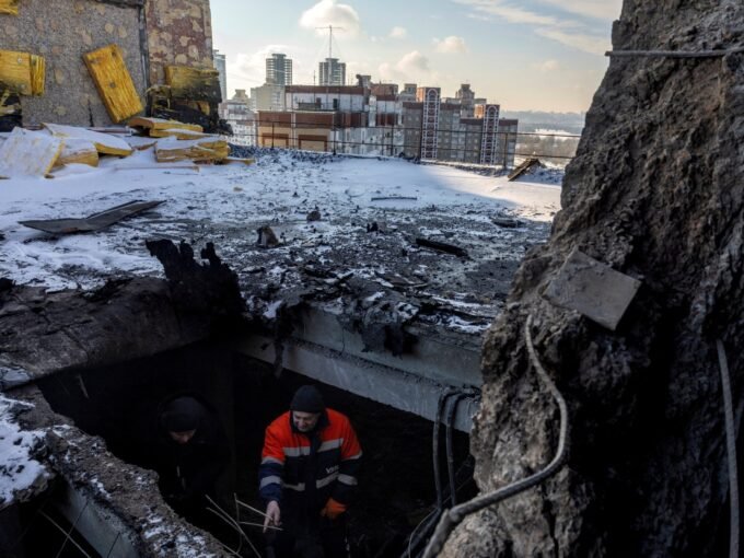 مقيم يشير إلى سقف مبنى سكني في كييف تضرر جراء هجوم بطائرة مسيرة روسية.