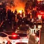 علمي الولايات المتحدة وإيران، يرمزان للتوترات الدبلوماسية والعقوبات المفروضة.