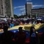 متظاهرون يحملون العلم الفنزويلي في كاراكاس، مطالبين بالإفراج عن الرئيس نيكولاس مادورو.