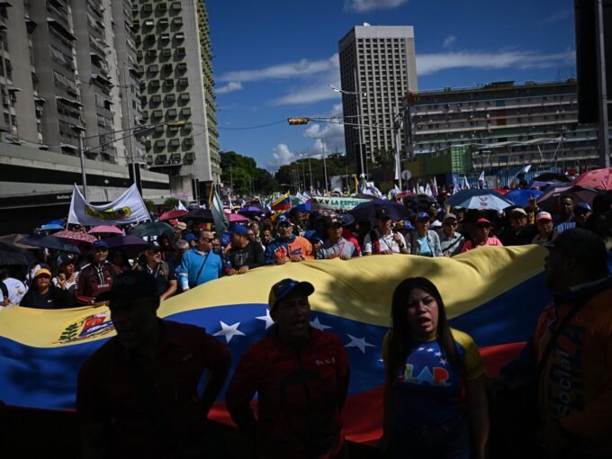 متظاهرون يحملون العلم الفنزويلي في كاراكاس، مطالبين بالإفراج عن الرئيس نيكولاس مادورو.