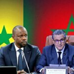 صورة تجمع مسؤولين مغاربة وسنغاليين خلال توقيع اتفاقيات تعاون، مع خلفية لمعالم مغربية ورياضية.