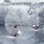 لاجئون سوريون يعبرون نهراً حدودياً بين سوريا ولبنان في ظروف خطرة