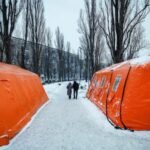 شخصان يسيران في كييف بالقرب من مركز تدفئة بعد هجمات روسية أدت لانقطاع التيار الكهربائي.