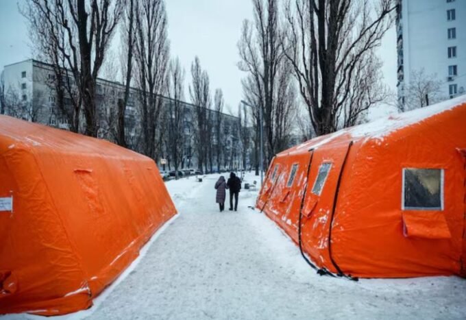 شخصان يسيران في كييف بالقرب من مركز تدفئة بعد هجمات روسية أدت لانقطاع التيار الكهربائي.