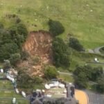 صورة تظهر آثار انهيار أرضي في منطقة جبل مونغانوي بنيوزيلندا مع ركام وأشجار متساقطة.