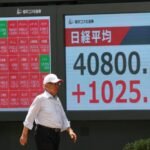 رجل يراقب شاشة عرض أسعار الأسهم لمؤشر نيكي خارج شركة وساطة في طوكيو، اليابان، بتاريخ 23 يوليو 2025.