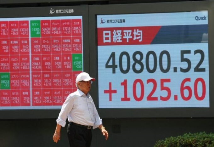 رجل يراقب شاشة عرض أسعار الأسهم لمؤشر نيكي خارج شركة وساطة في طوكيو، اليابان، بتاريخ 23 يوليو 2025.