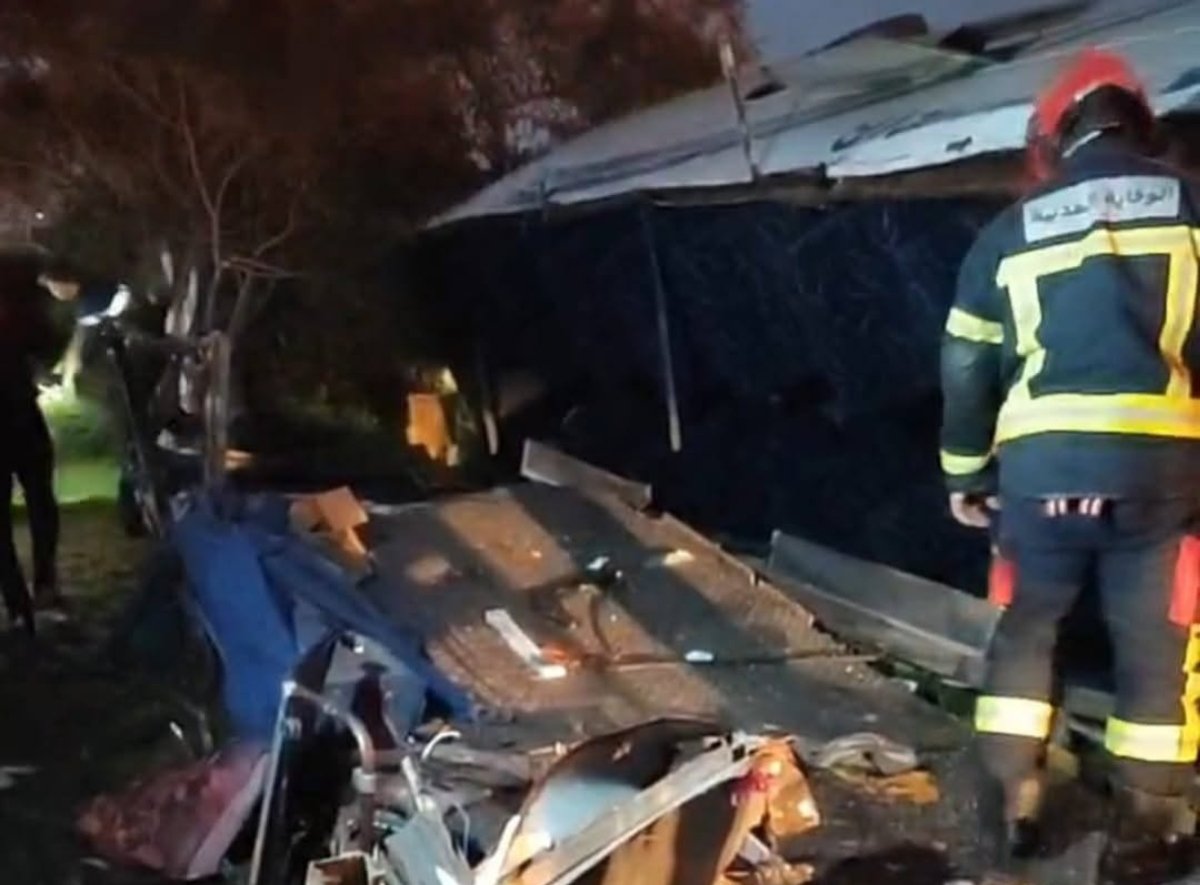 صورة لحافلة منقلبة على جانب الطريق بمنطقة عين حرودة مع تواجد سيارات إسعاف وعناصر أمنية.