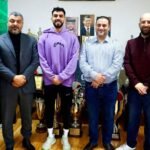 صورة تظهر رئيس نادي الوحدات يوسف الصقور ورئيس النادي الأهلي سمير صوبر وهما يصافحان اللاعب عبدالله عوض بعد توقيع عقد انتقاله.