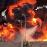 مقاتلون يمنيون ورجال إطفاء يحاولون إخماد حريق في مصفاة نفط بعدن عام 2015