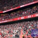 جماهير إفريقية متنوعة تحتفل في ملعب مغربي خلال كأس أمم إفريقيا 2025، رمزًا لتلاقح الثقافات والوحدة.