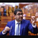 أستاذ مغربي يقف أمام سبورة في فصل دراسي، يرمز لكرامة المعلم في مواجهة تحديات الإشهار الرقمي.