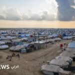 صورة جوية لمخيم الهول في سوريا يظهر فيه عدد كبير من الخيام، مع قوات أمنية في محيطه.