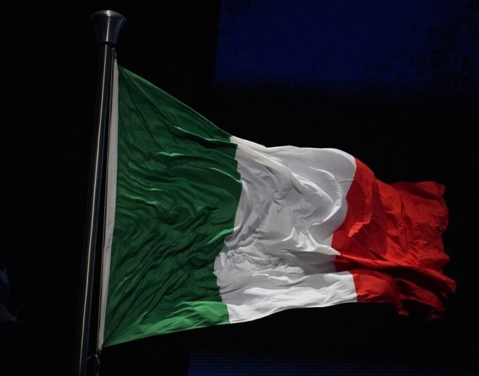 خريطة إيران وعلم إيطاليا مع إشارة إلى الأزمة الدبلوماسية والاحتجاجات.
