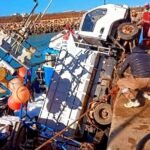 شاحنة بيضاء تستقر فوق مركب صيد أزرق داخل حوض ميناء آسفي بعد حادث غريب.