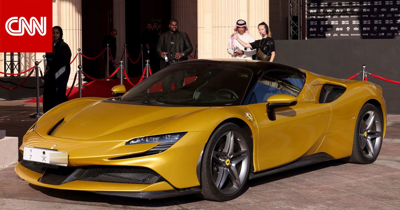 سيارة فيراري رياضية حمراء على سجادة حمراء خلال مهرجان البحر الأحمر السينمائي بجدة.