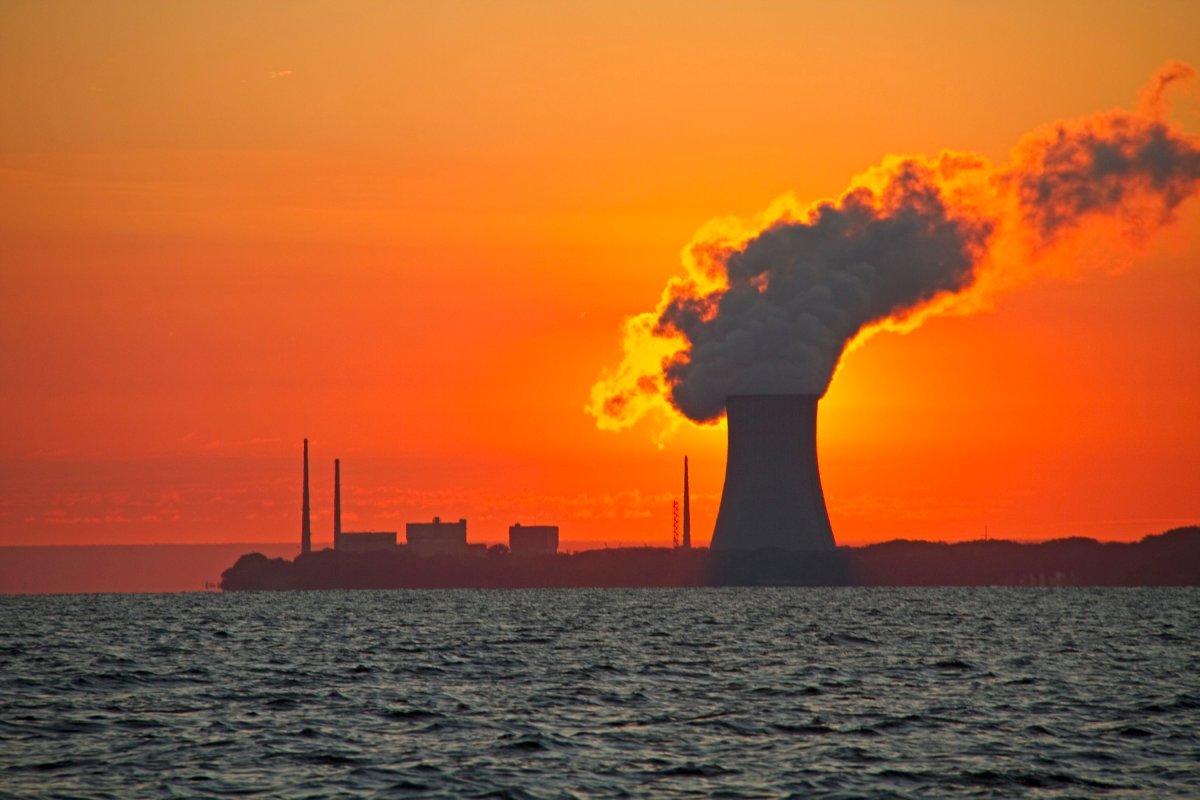Nuclear power plant facility with cooling towers, symbolizing energy and safety concerns.