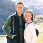 A young couple smiling confidently in a modern office setting, symbolizing entrepreneurial success and partnership.