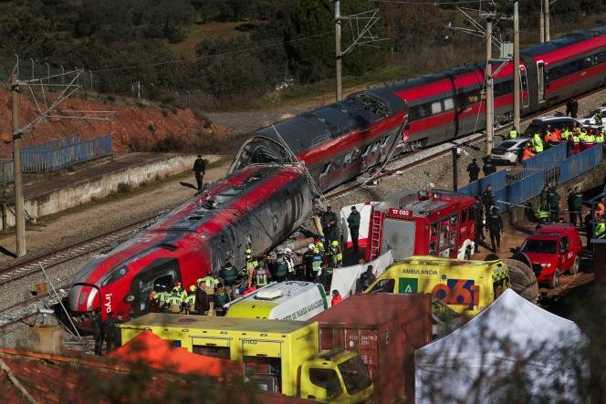 Espagne : Deuil National Après une Catastrophe Ferroviaire Meurtrière en Andalousie 3 Vue aérienne des wagons de train déraillés et endommagés après la collision en Andalousie, avec des équipes de secours et des véhicules d'urgence sur les lieux.